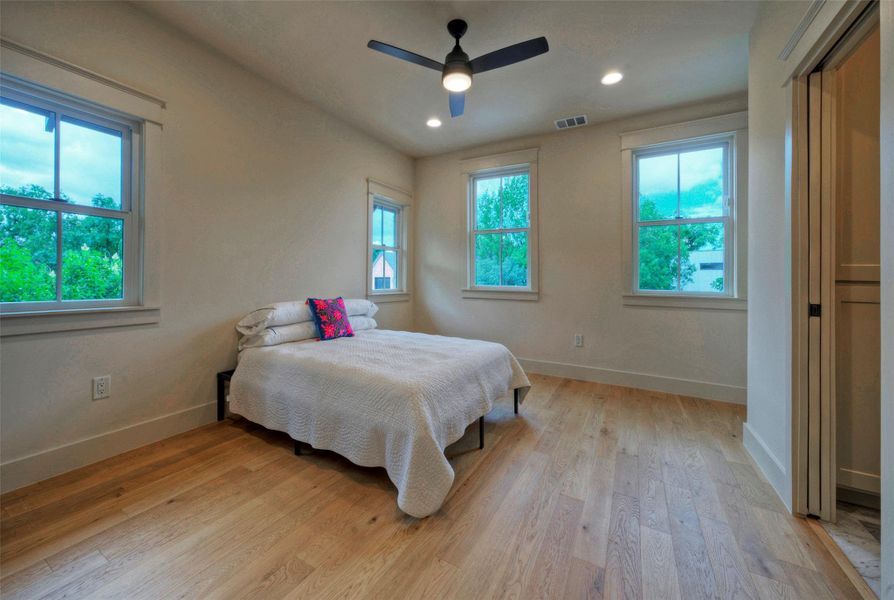 Hardwood floors and generous windows create a light and airy private room.