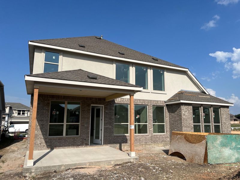 Back of property featuring brick siding, a patio area, and stucco siding Back of property featuring brick siding, a patio area, and stucco siding