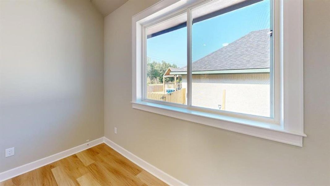 Empty room featuring wood finished floors and baseboards