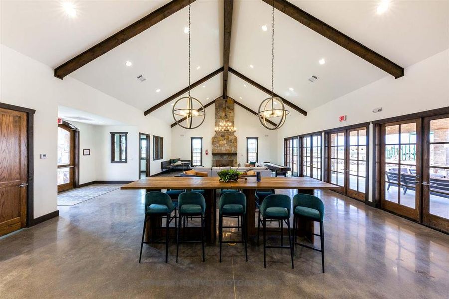Dining space with high vaulted ceiling, finished concrete floors, beamed ceiling, a chandelier, and recessed lighting Dining space with high vaulted ceiling, finished concrete floors, beamed ceiling, a chandelier, and recessed lighting