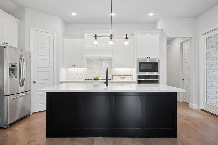 Modern kitchen featuring a black-paneled island with a white quartz countertops and a matte black faucet