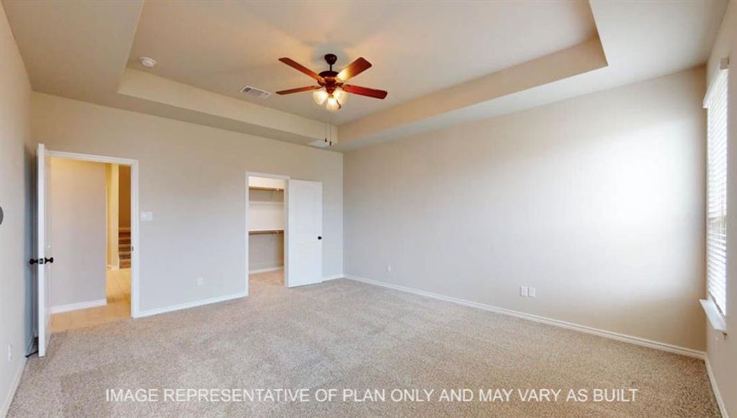 Unfurnished bedroom featuring a raised ceiling, light carpet, a walk in closet, and ceiling fan Unfurnished bedroom featuring a raised ceiling, light carpet, a walk in closet, and ceiling fan