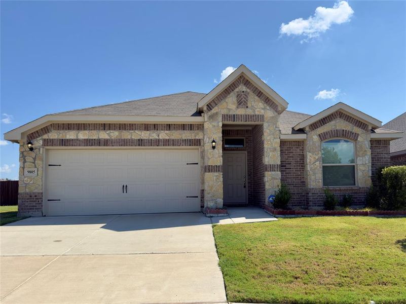 View of front of home with brick siding, stone siding, and a front yard View of front of home with brick siding, stone siding, and a front yard
