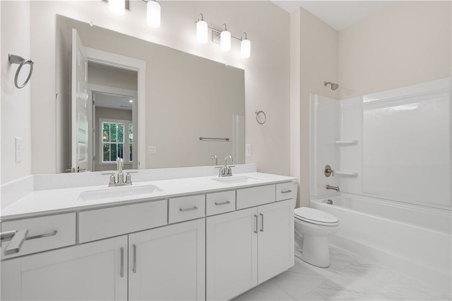 A spacious double vanity and tile flooring define