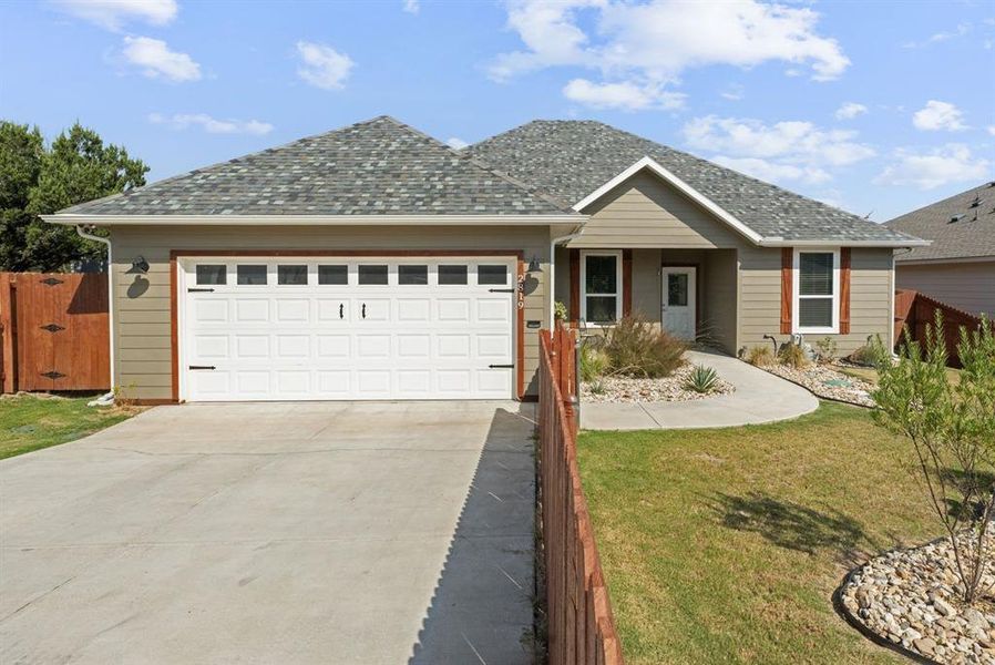 Ranch-style home with concrete driveway, a garage, a shingled roof, and a porch