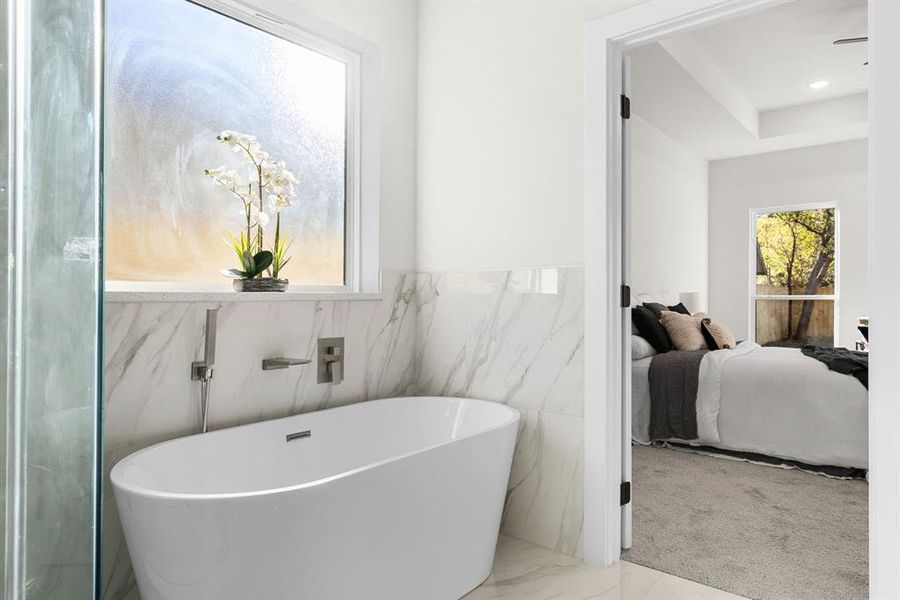 Bathroom featuring a bathtub and tile walls