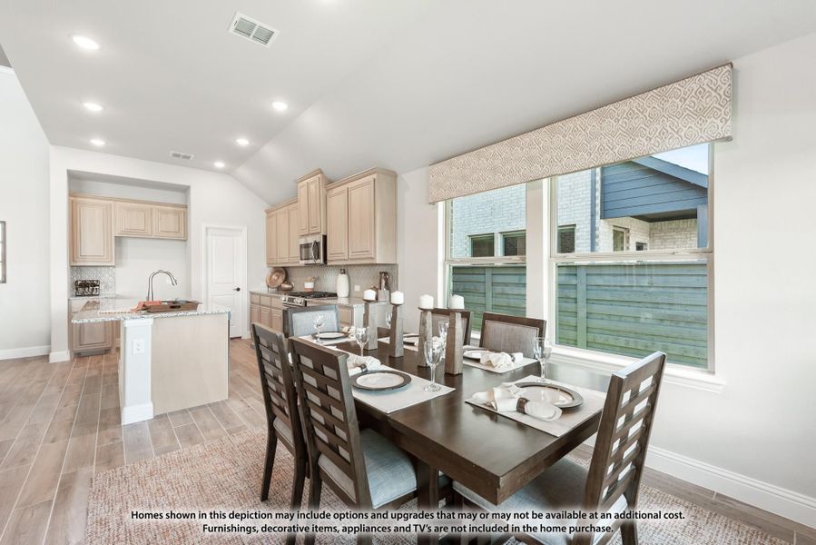 Open dining area with dark wood table and six chairs, adjacent to kitchen with light wood cabinets and vaulted ceiling