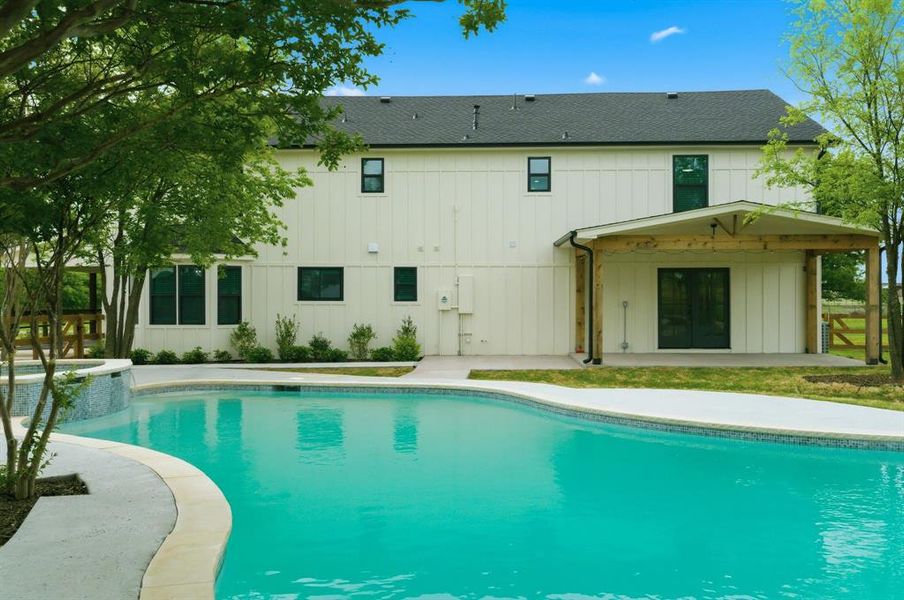 The property features a large outdoor swimming pool with a stone coping and a tiled spa area The property features a large outdoor swimming pool with a stone coping and a tiled spa area