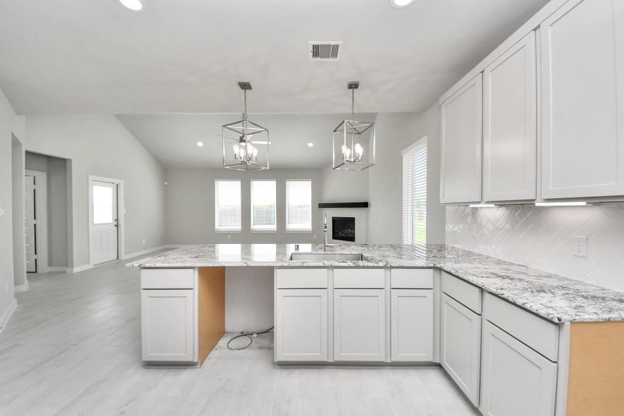 The extended counter area adds both practicality and style, making meal preparation a breeze. Every detail is thoughtfully designed to enhance the kitchen's functionality and aesthetic appeal. Sample photo of completed home with similar floor plan. Actual colors and selections may vary.