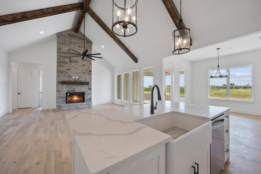 Kitchen with a chandelier, a sink, beam ceiling, light wood-style flooring, and stainless steel dishwasher Kitchen with a chandelier, a sink, beam ceiling, light wood-style flooring, and stainless steel dishwasher