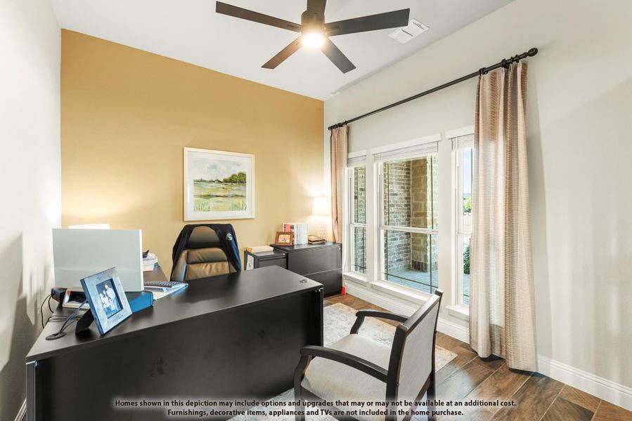 Home office with dark wood desk, ceiling fan, accent wall, and large windows with curtains Home office with dark wood desk, ceiling fan, accent wall, and large windows with curtains