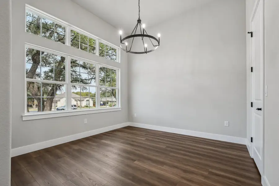 Unfurnished dining area with dark wood-style flooring and a chandelier