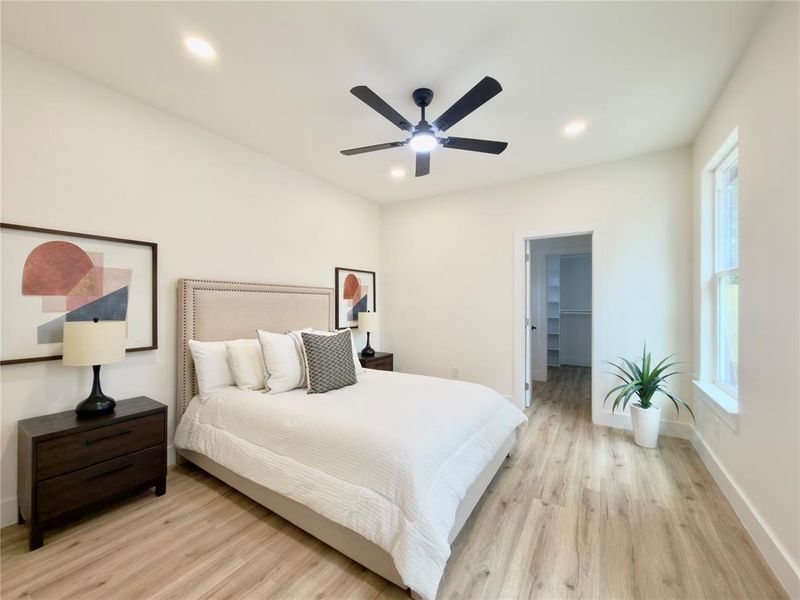 Spacious room featuring light wood-finish flooring, recessed lighting, and a modern ceiling fan