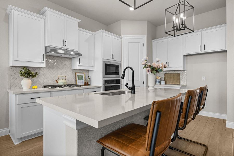 Kitchen featuring light wood-style floors, an island with sink, backsplash, and a breakfast bar area