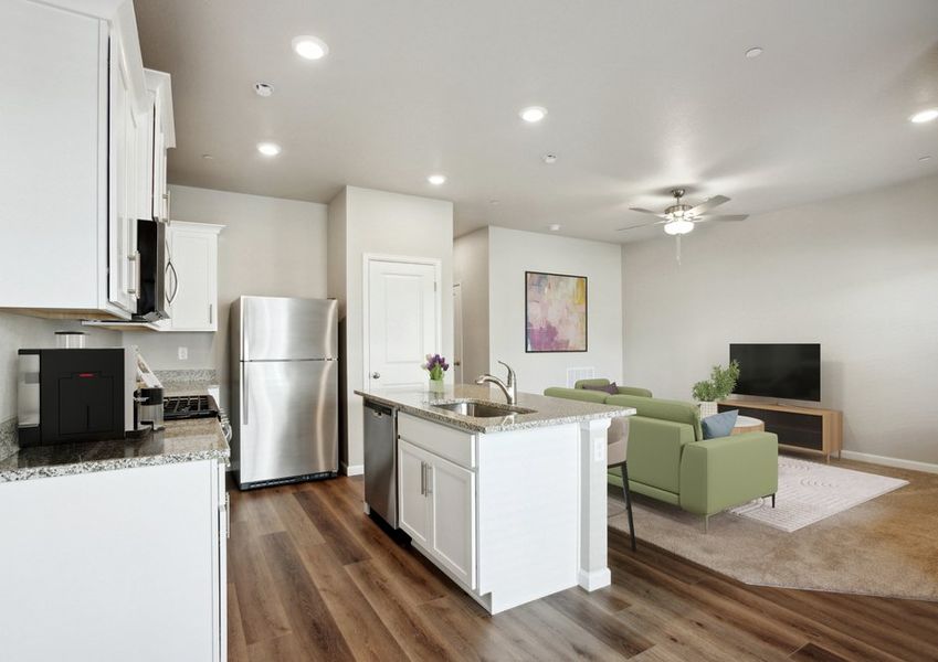 The kitchen has stainless steel appliances and plank flooring