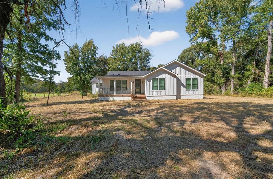 View of front of home featuring board and batten siding and a front lawn