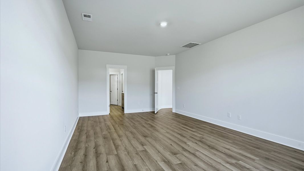 Serene and stylish primary bedroom featuring hardwood flooring and a thoughtful, modern layout at Mulberry Estates