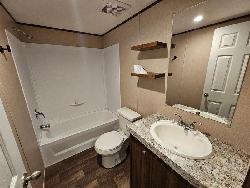 Bathroom with bathing tub / shower combination, dark wood-style flooring, and vanity Bathroom with bathing tub / shower combination, dark wood-style flooring, and vanity