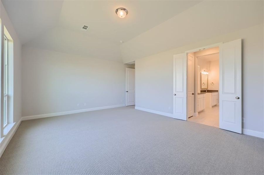 Spare room with lofted ceiling and light carpet