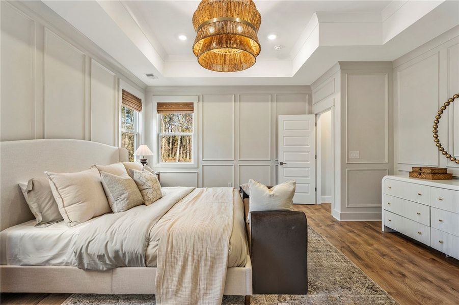 This spacious bedroom features elegant wainscoting