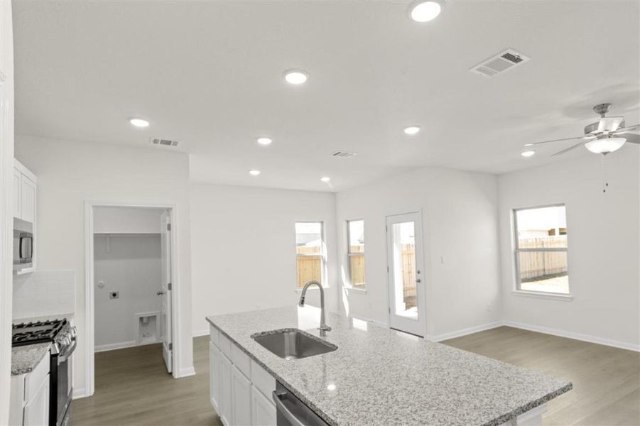 Kitchen with white cabinets, visible vents, stainless steel appliances, and a sink