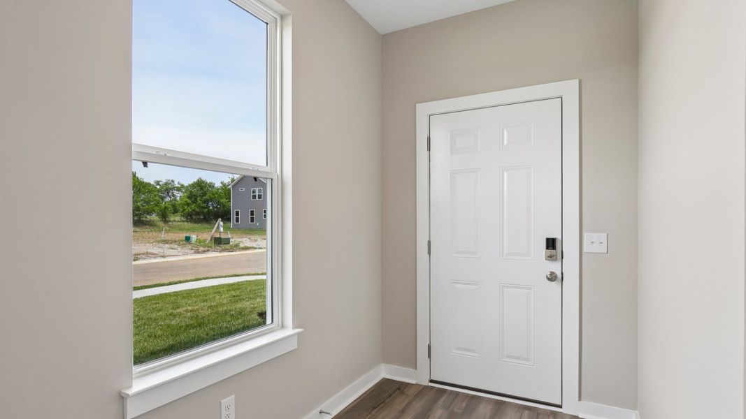 Front door to home with nearby window Front door to home with nearby window