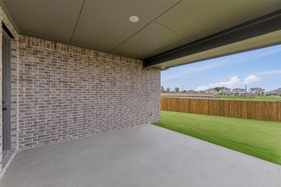 Covered patio featuring a concrete slab and a brick exterior wall Covered patio featuring a concrete slab and a brick exterior wall