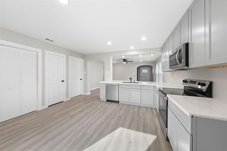 Kitchen featuring arched walkways, stainless steel appliances, a peninsula, recessed lighting, and ceiling fan Kitchen featuring arched walkways, stainless steel appliances, a peninsula, recessed lighting, and ceiling fan