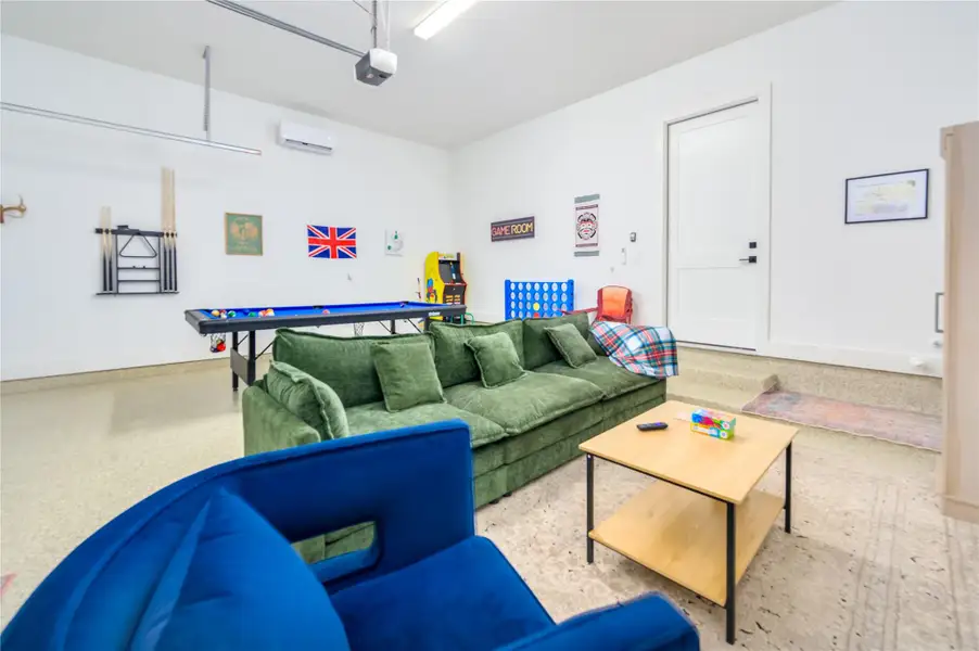 Finished out garage featuring epoxy floors, a mini-split AC and TV sitting area and ping pong table