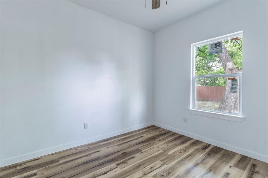 Unfurnished room with light wood-style floors, baseboards, and a ceiling fan Unfurnished room with light wood-style floors, baseboards, and a ceiling fan