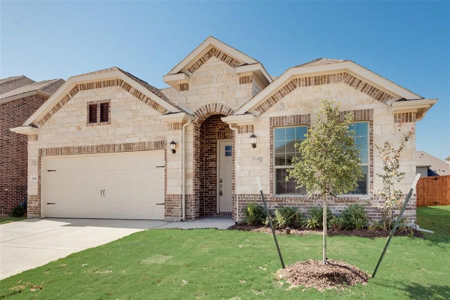 View of front of house with a front yard and a garage