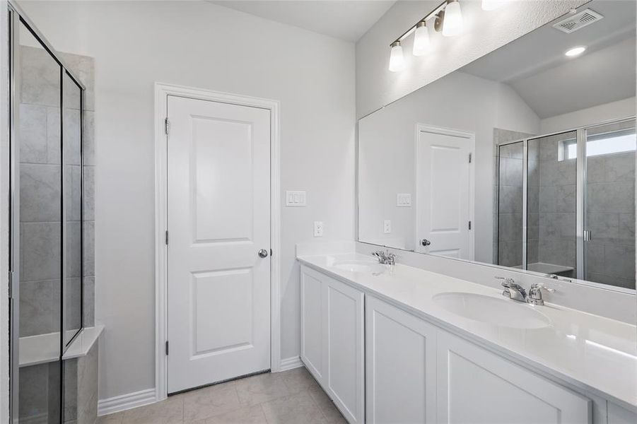 Full bathroom featuring double vanity, a shower stall, and lofted ceiling Full bathroom featuring double vanity, a shower stall, and lofted ceiling