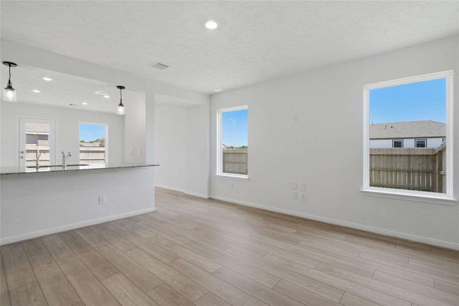 This bright and airy Great Room offers a spacious layout ideal for both relaxing evenings and lively gatherings. Designed for comfort and connection, it features vinyl plank flooring, large windows, high ceilings, recessed lighting, and seamless access to the stunning kitchen.