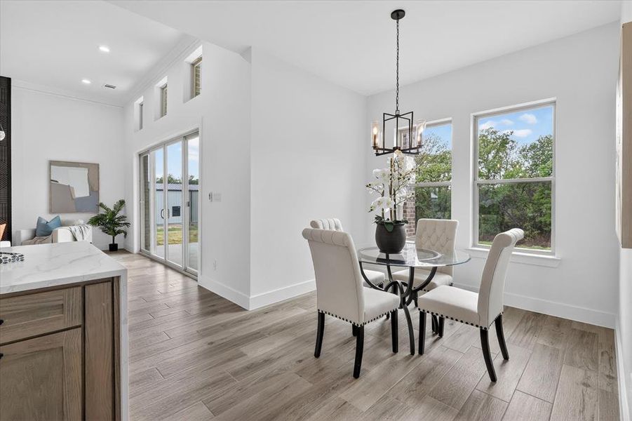 Dining area with light wood-style floors and a chandelier