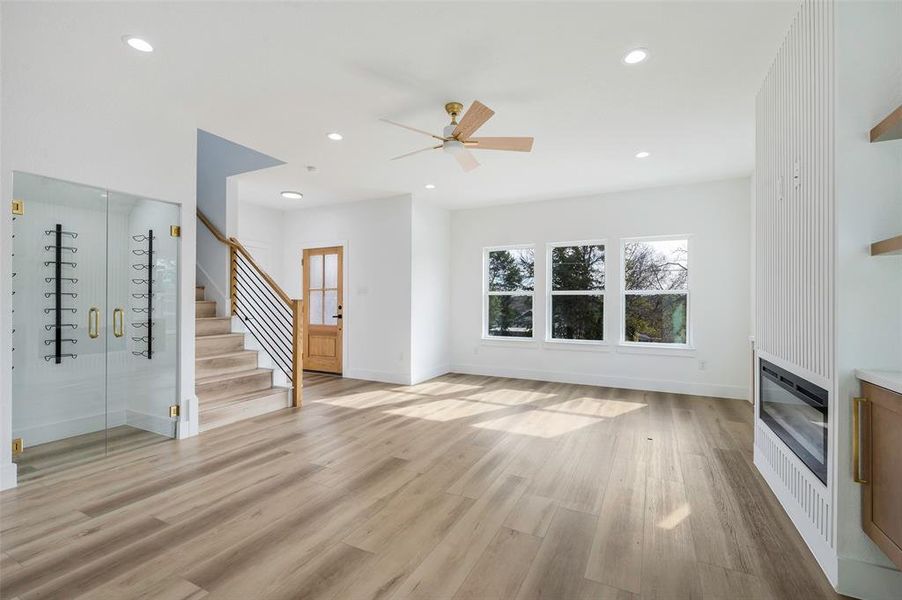 Unfurnished living room with heating unit, ceiling fan, and light wood-type flooring