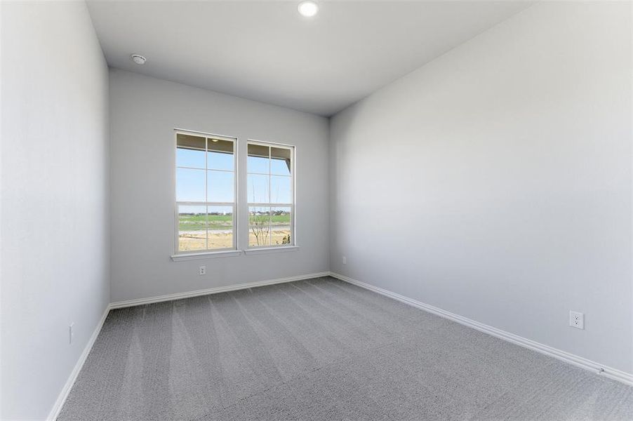 Empty room featuring carpet and baseboards
