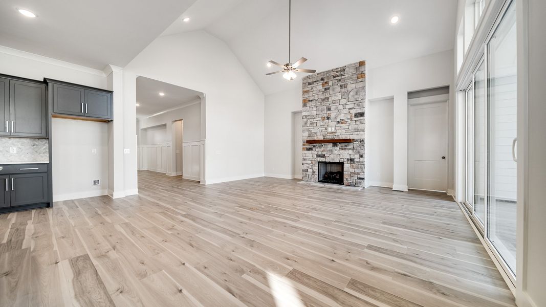 Large living room area with vaulted ceiling and stone fireplace