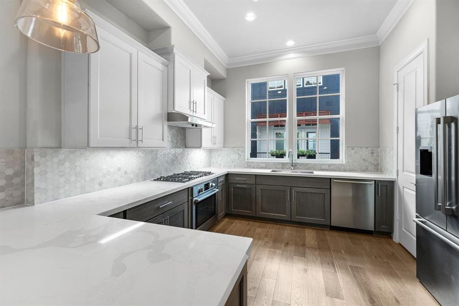 Undercabinet lighting enhances the beauty of the space, casting a warm glow on the stunning backsplash and creating an inviting atmosphere for cooking and entertaining.