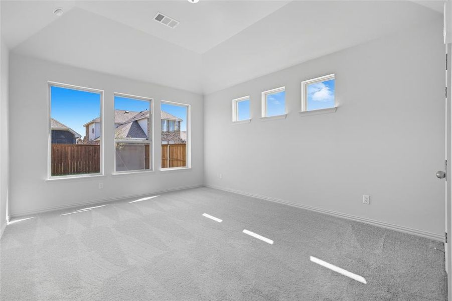 Spare room featuring light colored carpet, plenty of natural light, and vaulted ceiling Spare room featuring light colored carpet, plenty of natural light, and vaulted ceiling