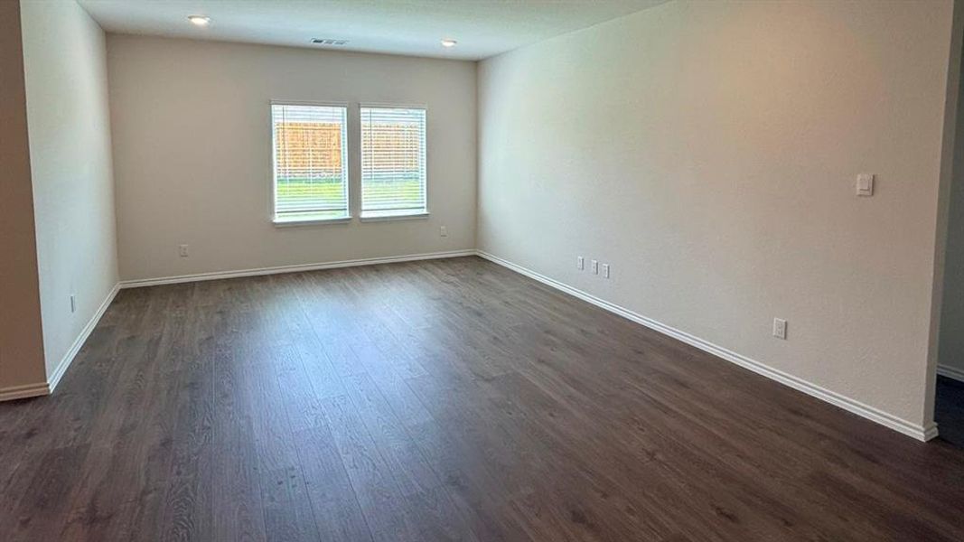 Empty room with baseboards and dark wood-type flooring Empty room with baseboards and dark wood-type flooring