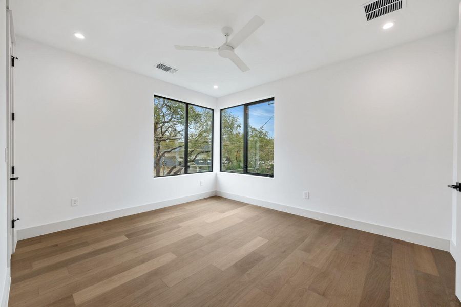 Guest room featuring light wood-type flooring, ceiling fan, and recessed lighting