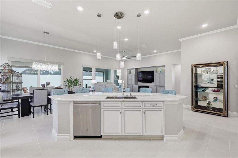 Central kitchen island with white cabinetry and integrated stainless steel dishwasher