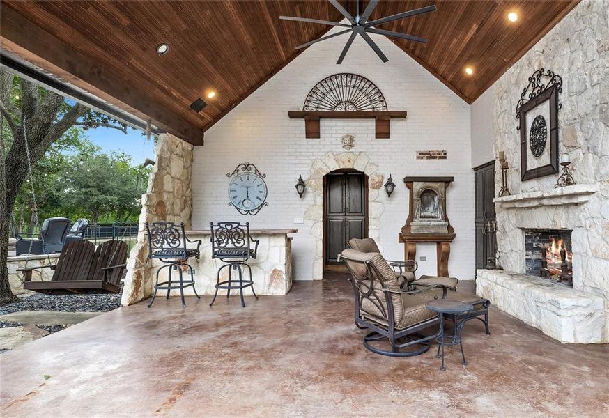 View of patio / terrace featuring ceiling fan and an outdoor stone fireplace