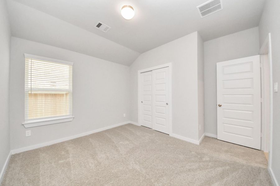 Generously sized secondary bedrooms featuring spacious closets, soft and inviting carpeting underfoot, large windows allowing plenty of natural light, and the added touch of privacy blinds for your personal retreat. Sample photo of completed home with similar floor plan. Actual colors and selections may vary.