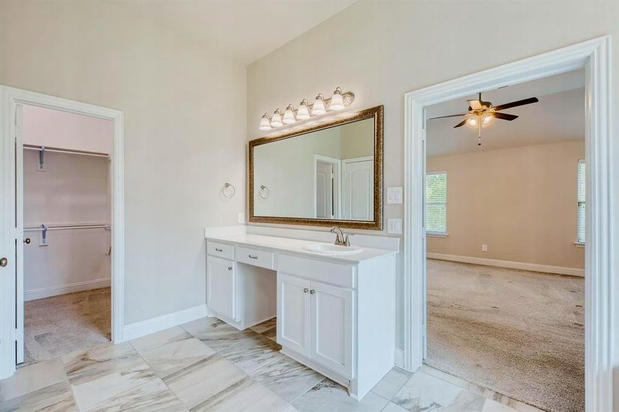 Bathroom with ceiling fan, tile patterned floors, and vanity