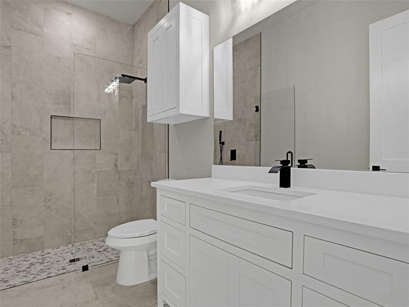 Bathroom with vanity, toilet, and a tile shower