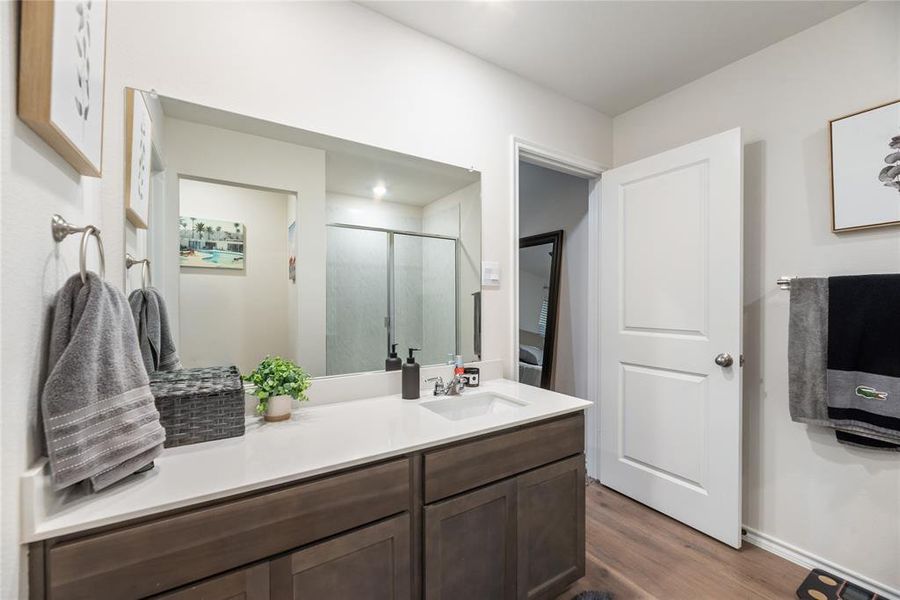 Bathroom with vanity, a shower stall, and dark wood-style floors