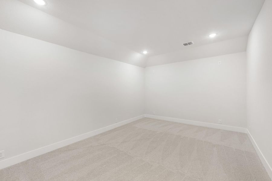 Empty room with white walls, beige carpet, and recessed ceiling lights
