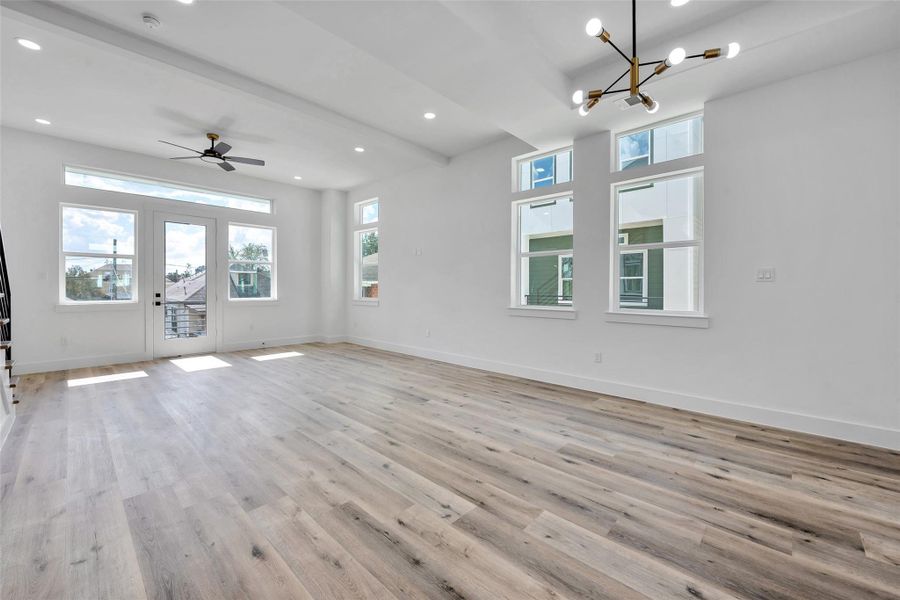 The main living floor is an expansive space with lots of windows, brushed brass light fixtures, and a balcony.