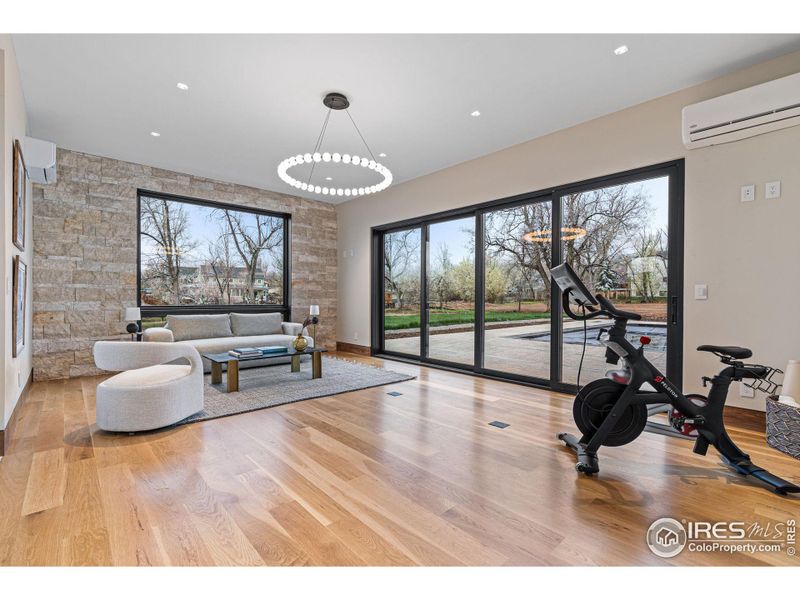 Pool house provides an additional living space or exercise room. Multi-panel sliding glass door opens to the pool/spa & 2,500+ SqFt patio. Includes living area, sauna, steam shower, changing room & water closet.  Tech Lighting chandelier.